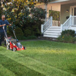 Man using lawnmower to create stripes in lawn