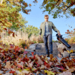 man clears leaf covered patio with leaf blower