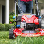 Close up of the front of a Toro lawnmower cutting green grass