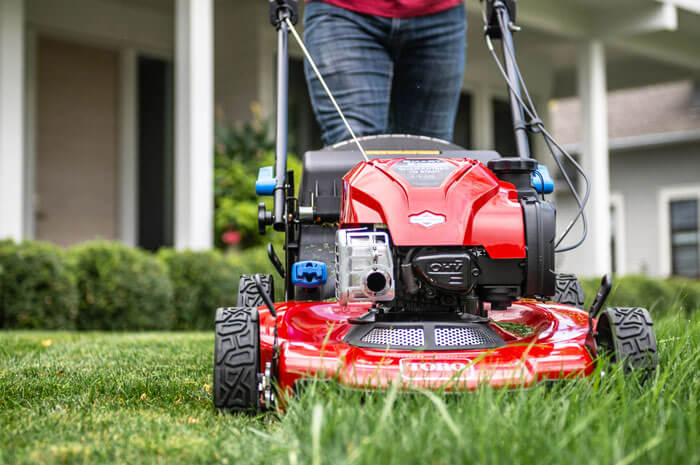 Close up of the front of a Toro lawnmower cutting green grass