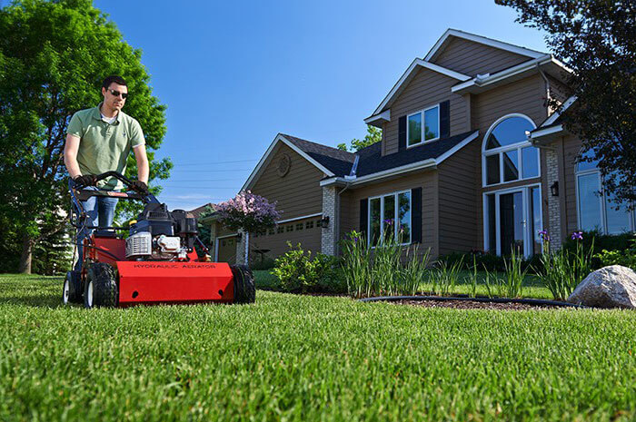 Man using Toro Hydraulic Aerator in front yard