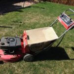 Toro lawnmower in a backyard with a brown fence in the background