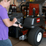 Person using wrench to conduct engine maintenance on Toro Zero Turn Mower