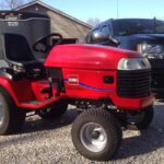 Red Toro riding mower in front of a black Chevy truck