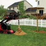 Man drilling holes in yard for fence posts with Toro product