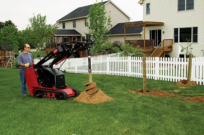 Man drilling holes in yard for fence posts with Toro product