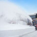 Man using snowblower to clear driveway of fresh snow