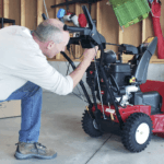 Man in garage assembling a Toro Two Stage Snowblower