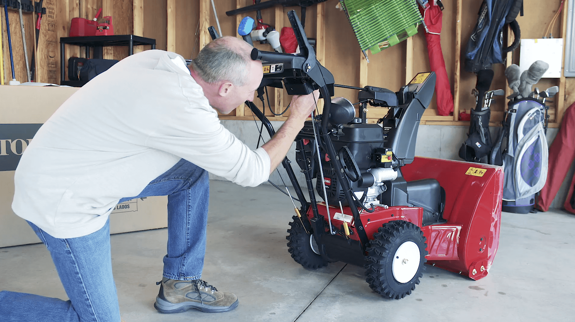 Man in garage assembling a Toro Two Stage Snowblower
