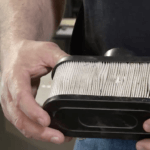 Man holding dirty lawnmower air filter