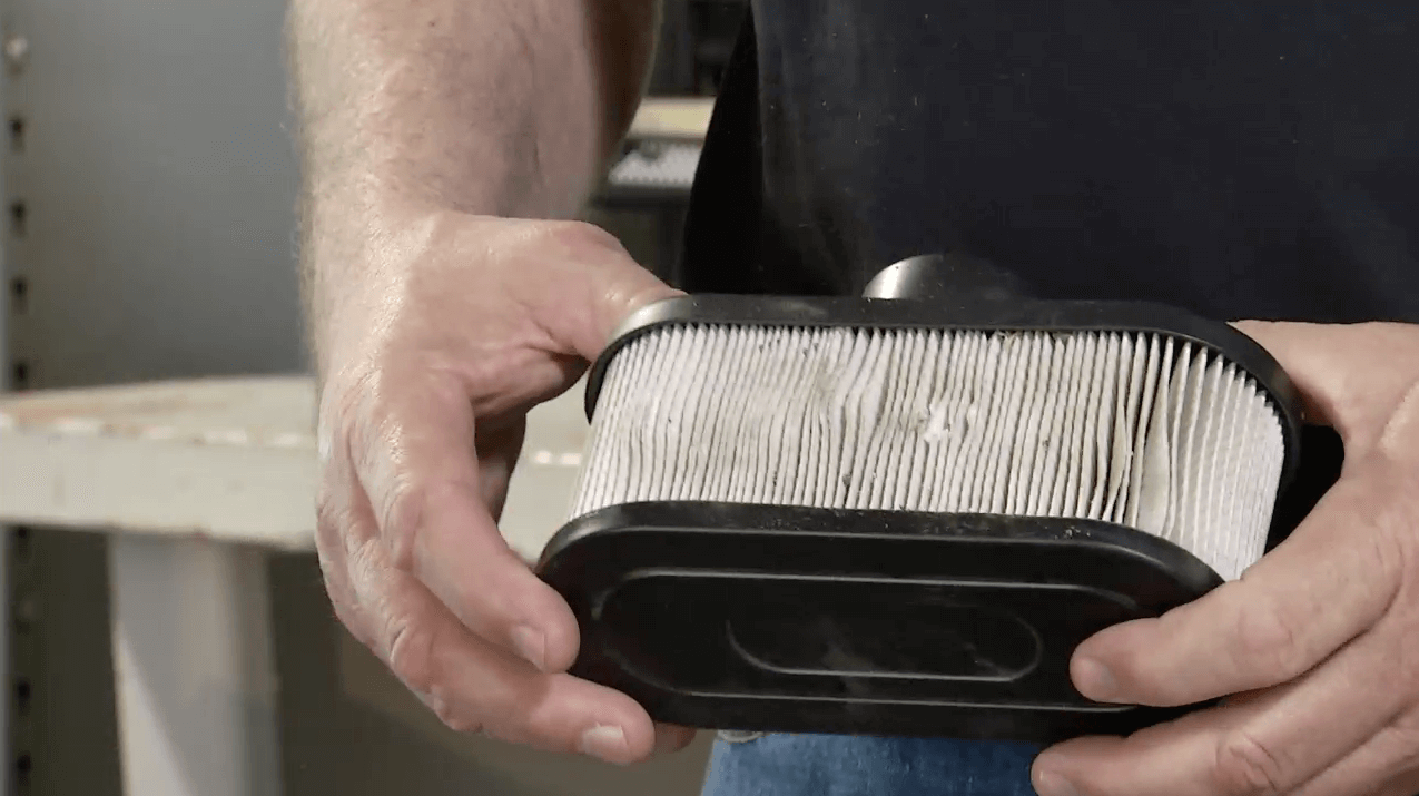 Man holding dirty lawnmower air filter
