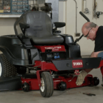 Man removing the mower deck of a Toro TimeCutter