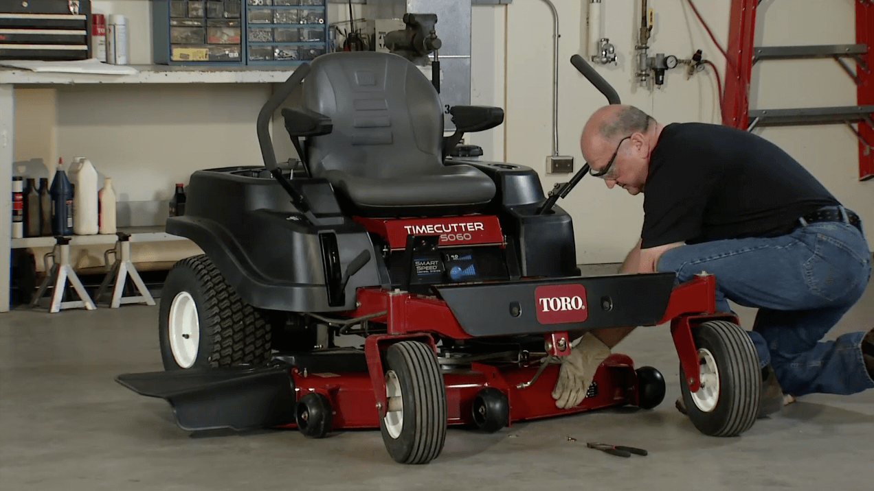 Man removing the mower deck of a Toro TimeCutter