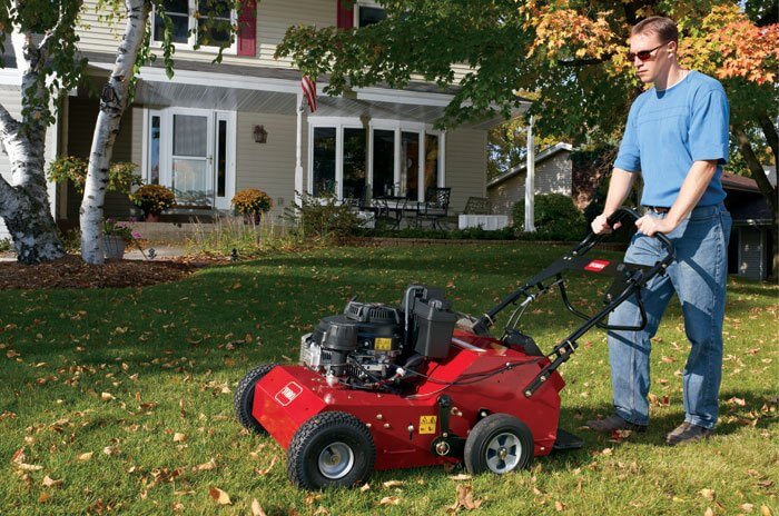 Man in blue shirt and glasses using Toro product to improve the health of his lawn