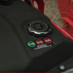 Close up of black fuel tank on lawnmower featuring three types of fuel; E10, E15, E85 with a green circle around E10 and a red circle around E15 and E85 with a warning label stating "Use of E85 & E15 in this product is prohibited by federal law".