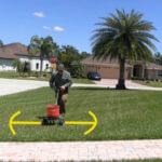 Man fertilizing lawn with yellow arrows on both sides pointing away from fertilizer