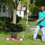 Man posing with Toro lawnmower as he mows his front lawn