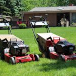 Two Toro lawnmowers in front yard