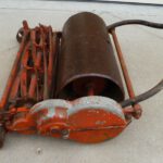 Old model of Toro push mower with orange blades
