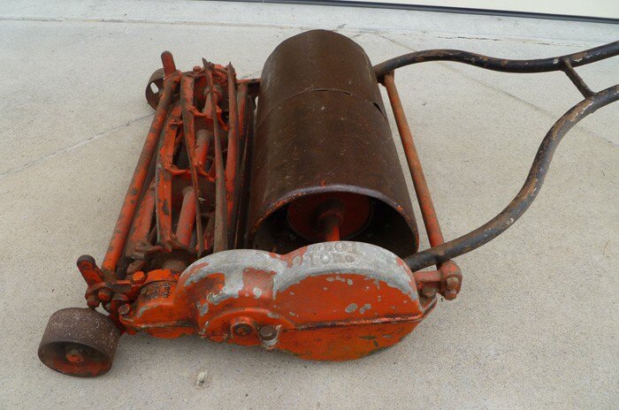 Old model of Toro push mower with orange blades