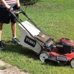 Man standing with hands on Toro lawnmower