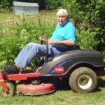 Man in blue shirt sitting on Toro riding mower