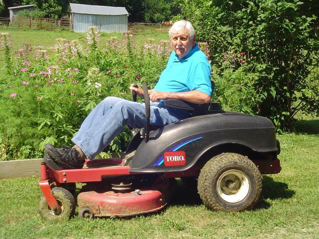 Man in blue shirt sitting on Toro riding mower