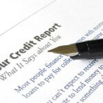 White paper that says "Your Credit Report" at the top and "What it says about you" under it with black ink pen resting on the page.