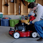 Man in garage adding gas to lawnmower