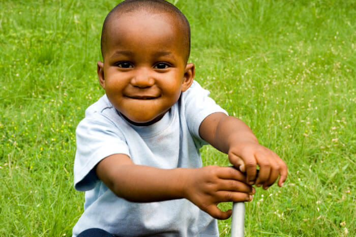 Small child smiling sitting in grass