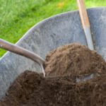 Shovels scooping dirt out of wheelbarrow