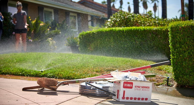 Yard with tools and equipment on the curb ready for an irrigation project