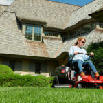 Woman riding on Toro Timecutter in front yard