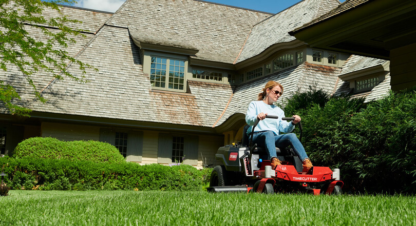 Woman riding on Toro Timecutter in front yard