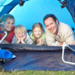 Family smiling for photo in blue tent