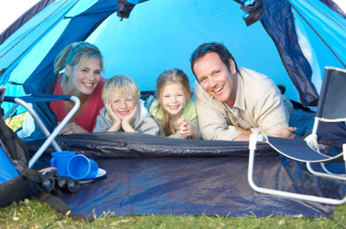 Family smiling for photo in blue tent