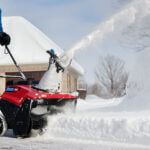 Man clearing driveway of snow with Toro snowblower