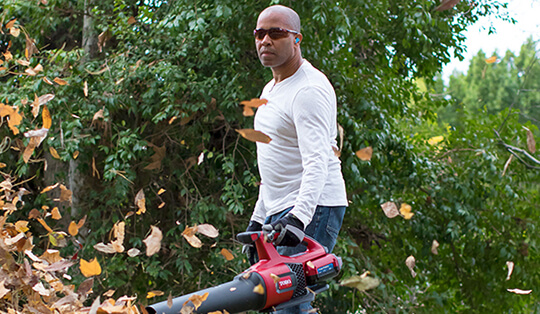 Man using a blower to blow leaves