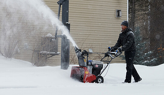 Man using a snow blower in the snow