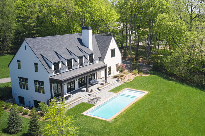 arial shot of sprawling backyard featuring firescaping features like a stone patio and pool
