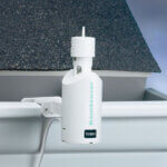 Rain sensor shown attached to a home's rain gutters.