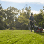 woman mows lawn of residential home